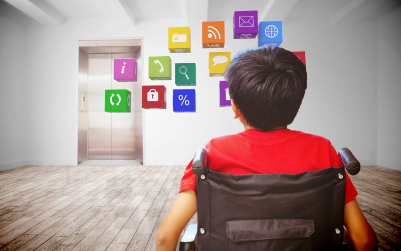 Rear view of boy sitting in wheelchair against room with elevator